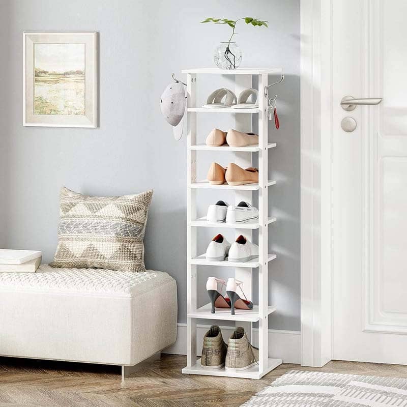 White shoe rack with shoes in a room with a couch and decor